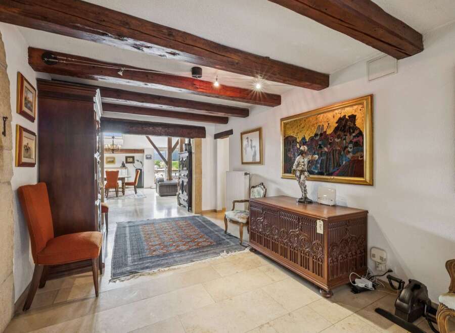Experience rustic charm in this spacious entryway featuring exposed wooden beams and elegant stone accents.