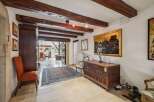 Experience rustic charm in this spacious entryway featuring exposed wooden beams and elegant stone accents.