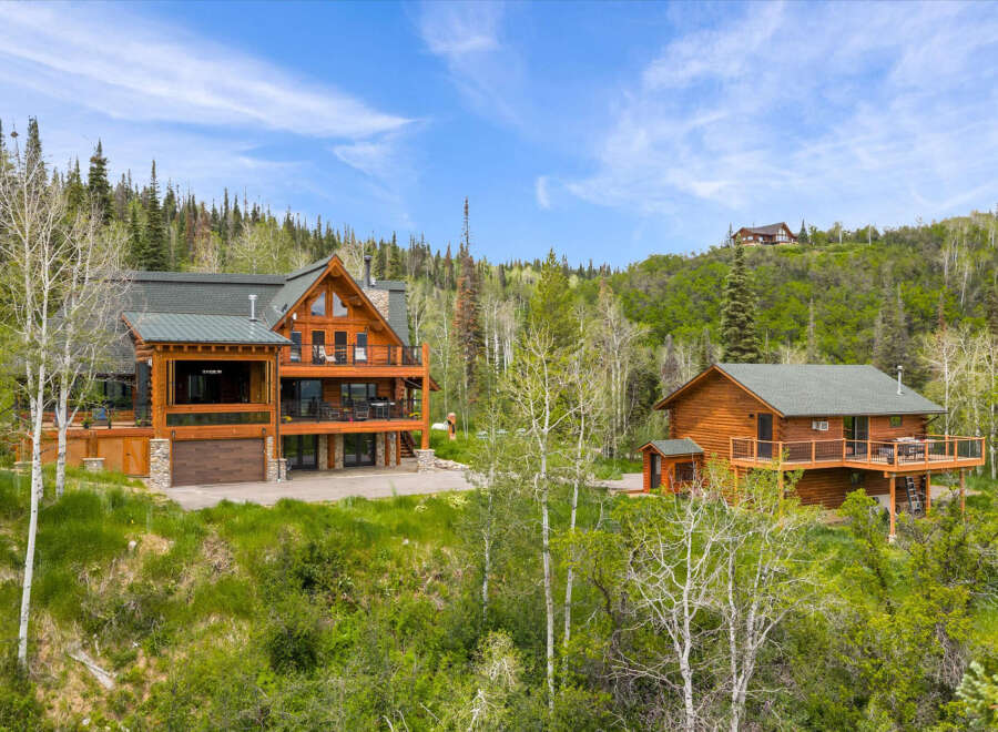 Experience luxury mountain living in this stunning log home estate, nestled amidst a serene forest landscape.