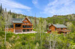 Experience luxury mountain living in this stunning log home estate, nestled amidst a serene forest landscape.