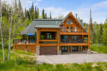 Experience luxury mountain living in this stunning log home, nestled amidst a serene forest landscape.