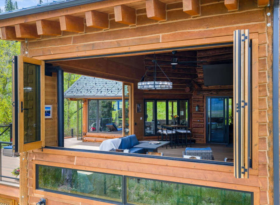 Experience seamless indoor-outdoor living with this stunning log home featuring a massive bi-fold window that opens to a spacious deck.
