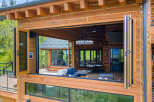Experience seamless indoor-outdoor living with this stunning log home featuring a massive bi-fold window that opens to a spacious deck.