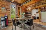 Experience rustic charm in this cozy dining area, featuring a round wooden table with a glass top, perfect for intimate meals.