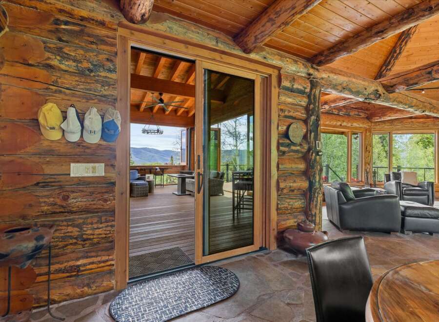 Experience rustic luxury in this stunning log cabin home, featuring a spacious great room with a soaring wood-beamed ceiling and a cozy stone fireplace.