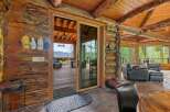 Experience rustic luxury in this stunning log cabin home, featuring a spacious great room with a soaring wood-beamed ceiling and a cozy stone fireplace.