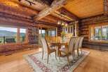 Experience rustic luxury in this stunning log home dining room, featuring a grand wooden table perfect for gatherings and surrounded by plush seating.