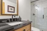 Experience modern luxury in this stunning bathroom featuring a sleek vanity with a granite countertop and a contemporary black faucet.