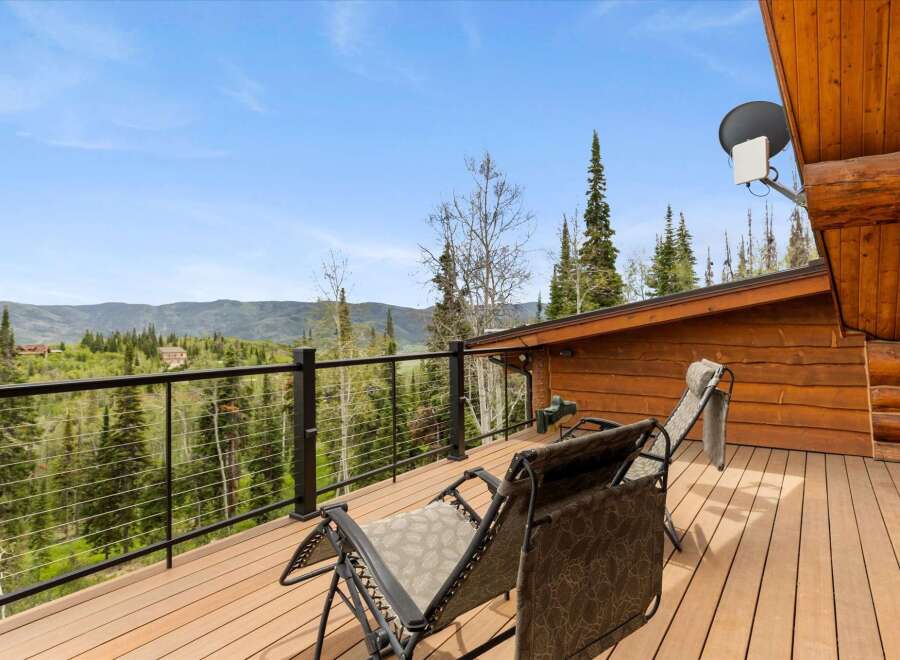 Enjoy breathtaking mountain views from this stunning log cabin deck, perfect for relaxing or entertaining.