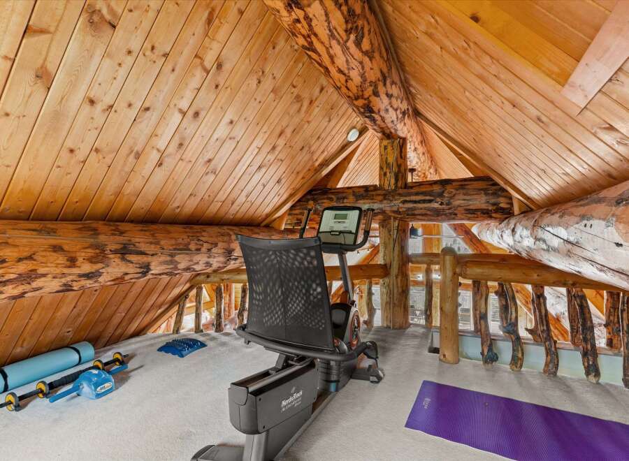 Elevate your wellness routine in this unique loft gym, featuring a recumbent exercise bike and yoga accessories.