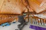 Elevate your wellness routine in this unique loft gym, featuring a recumbent exercise bike and yoga accessories.