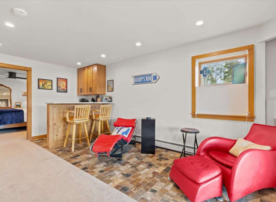 This inviting space features a charming bar area with wooden stools, perfect for entertaining guests.
