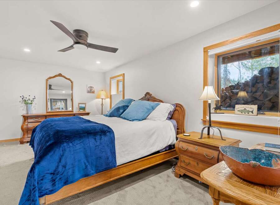 Experience rustic charm in this cozy bedroom, featuring a comfortable bed adorned with plush blue bedding and a luxurious velvet throw.