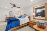 Experience rustic charm in this cozy bedroom, featuring a comfortable bed adorned with plush blue bedding and a luxurious velvet throw.
