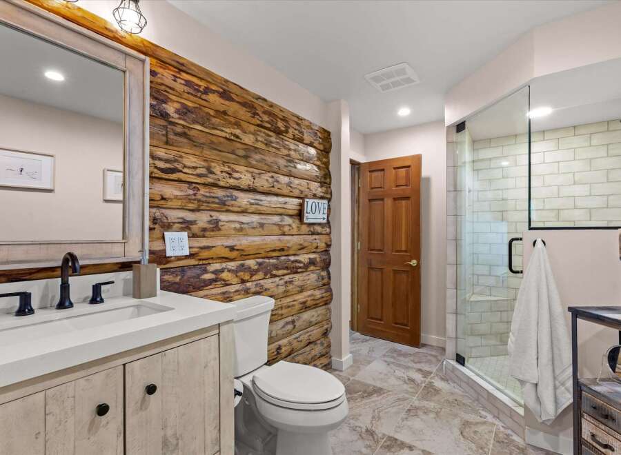 Experience rustic charm in this beautifully appointed bathroom, featuring a striking log accent wall that adds warmth and character.