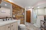 Experience rustic charm in this beautifully appointed bathroom, featuring a striking log accent wall that adds warmth and character.