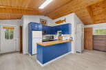Discover this charming kitchen featuring vibrant blue cabinetry and a butcher block countertop, perfect for meal preparation.