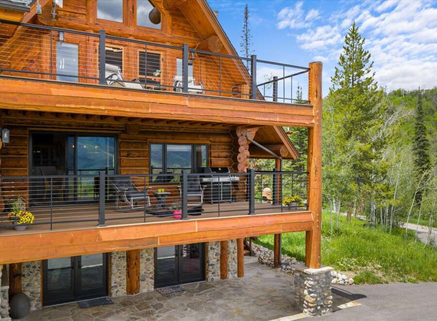 Experience luxury mountain living in this stunning log home, featuring multiple levels of expansive decks perfect for entertaining or enjoying the serene natural surroundings.