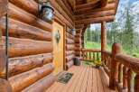 Experience rustic charm with this inviting log cabin entrance, featuring a warm wooden door and a welcoming porch.