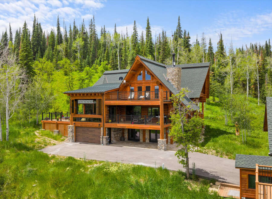 Experience luxury mountain living in this stunning log home, nestled amidst a lush forest.