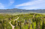 Nestled amidst rolling green hills and mature trees, this property offers a serene mountain retreat.