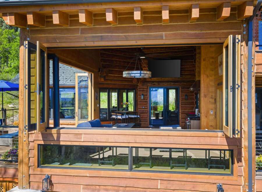 Experience seamless indoor-outdoor living with this stunning log home featuring expansive bi-fold doors that open to a spacious deck.