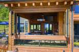 Experience seamless indoor-outdoor living with this stunning log home featuring expansive bi-fold doors that open to a spacious deck.