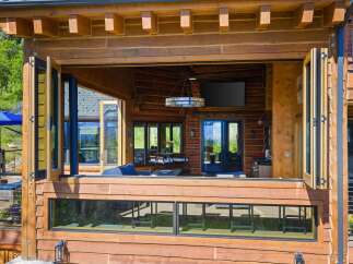 Experience seamless indoor-outdoor living with this stunning log home featuring expansive bi-fold doors that open to a spacious deck.