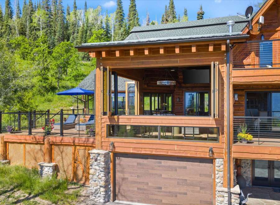 Experience luxury mountain living in this stunning log home, featuring expansive decks and panoramic forest views.