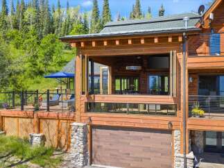 Experience luxury mountain living in this stunning log home, featuring expansive decks and panoramic forest views.