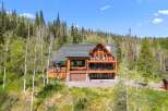 Experience luxury mountain living in this stunning log home, nestled amidst a serene forest landscape.