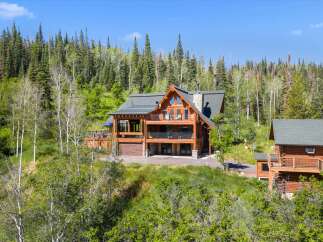 Experience luxury mountain living in this stunning log home nestled amidst a serene forest.