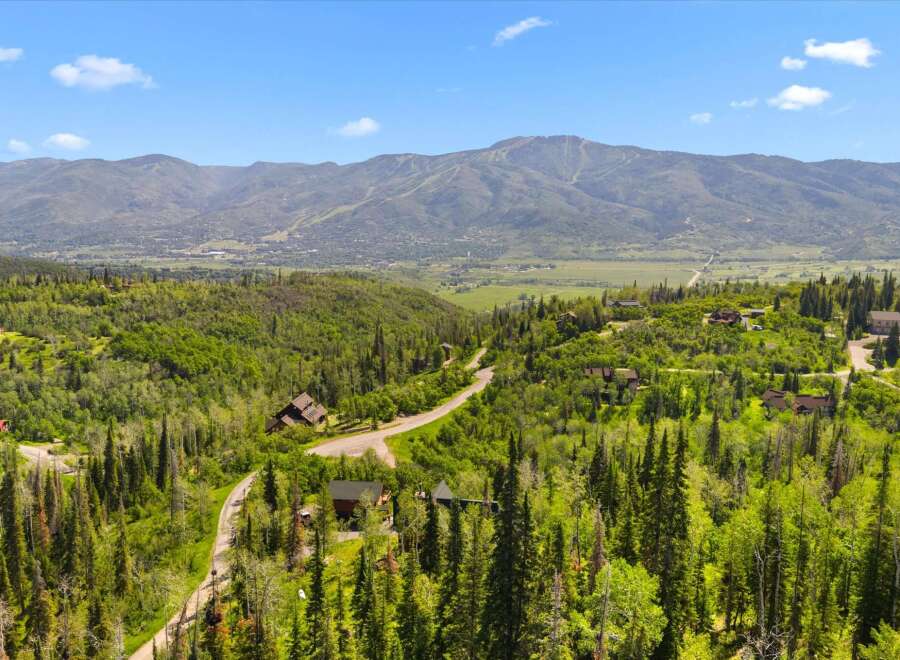 Nestled amidst lush greenery and towering pine trees, this stunning property offers breathtaking panoramic views of the majestic mountains.