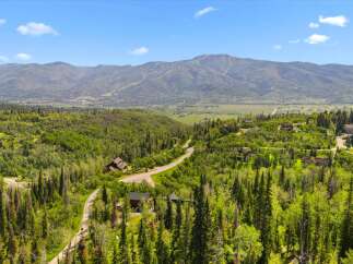 Nestled amidst lush greenery and towering pine trees, this stunning property offers breathtaking panoramic views of the majestic mountains.