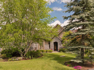 Discover this charming home featuring a beautiful stone facade and an arched entryway, perfect for welcoming guests.