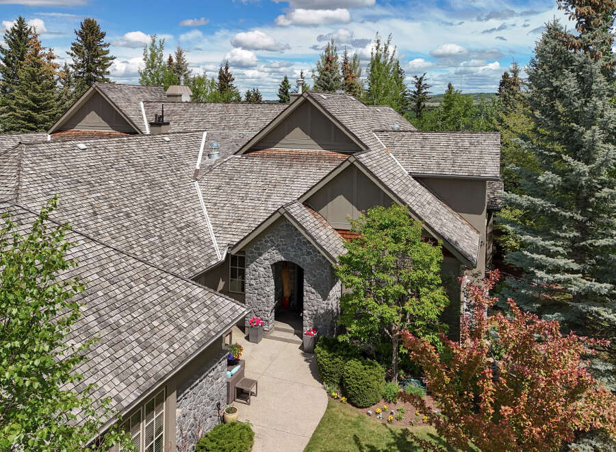 Discover this stunning home featuring a distinctive stone-accented arched entryway, perfect for welcoming guests.