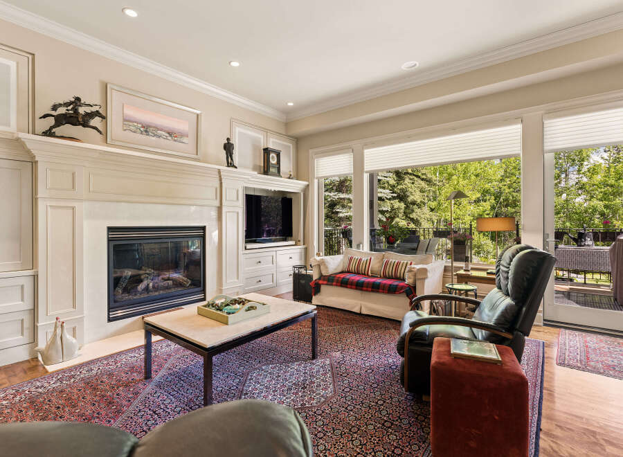 This inviting living room features a grand fireplace with intricate molding, perfect for cozy evenings.