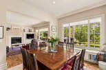 This elegant dining room features a large wooden table with seating for eight, perfect for hosting gatherings.