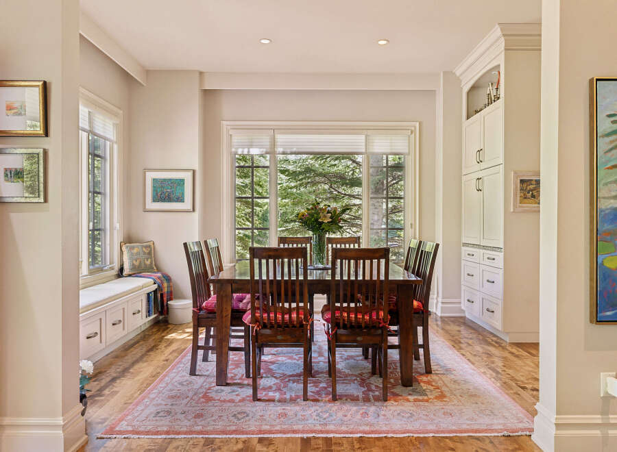 This elegant dining room features a large wooden table with six chairs, perfect for family gatherings.