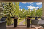 Enjoy your morning coffee on this charming covered deck, overlooking a beautifully landscaped backyard with a winding stone pathway.