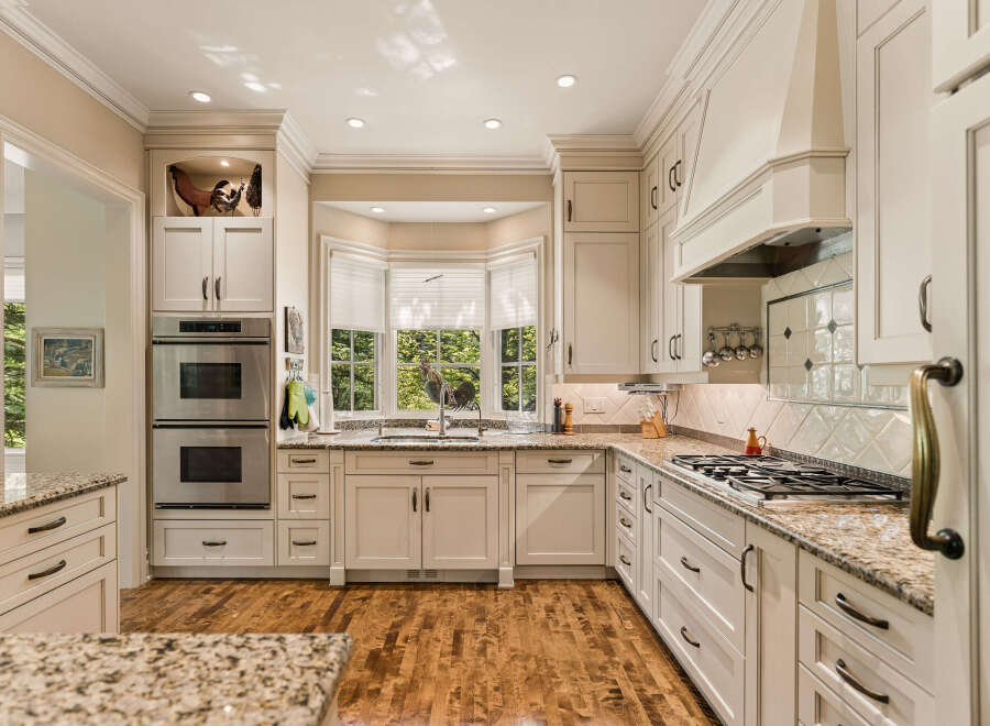 Experience culinary excellence in this stunning kitchen, featuring elegant cream cabinetry and a spacious granite countertop.