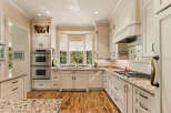 Experience culinary excellence in this stunning kitchen, featuring elegant cream cabinetry and a spacious granite countertop.