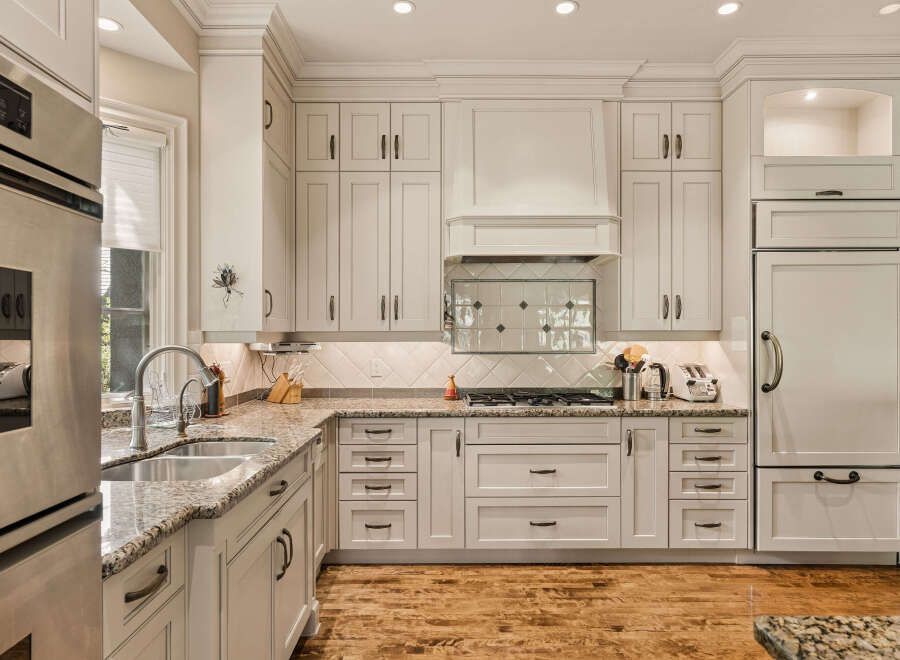 Experience luxury in this stunning kitchen, featuring custom cream cabinetry and exquisite granite countertops.