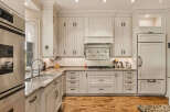 Experience luxury in this stunning kitchen, featuring custom cream cabinetry and exquisite granite countertops.