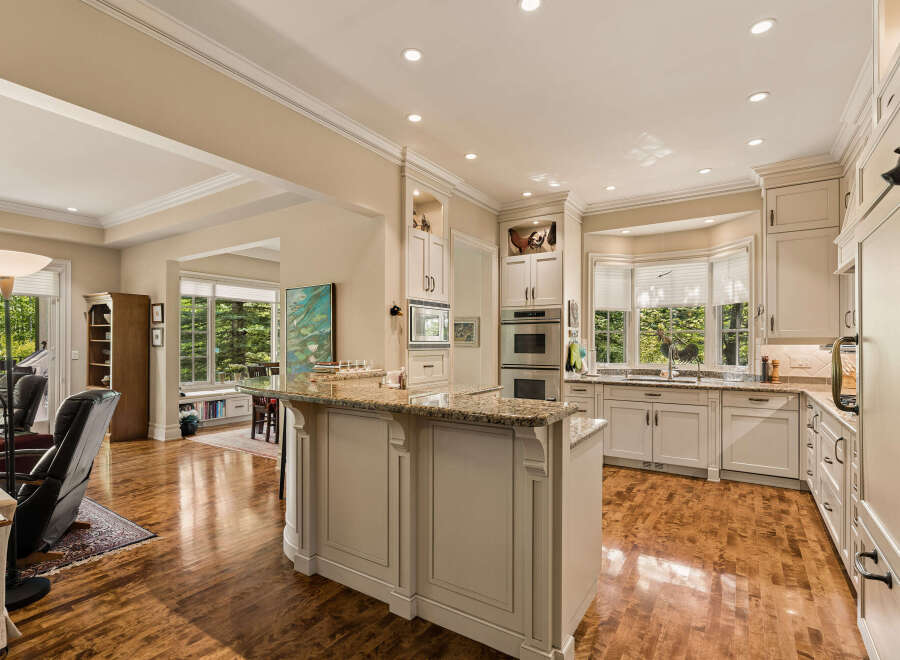 This spacious kitchen boasts elegant cream cabinetry, granite countertops, and a large island perfect for entertaining.