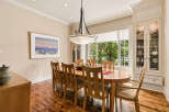 This elegant dining room features a large oval wooden table with eight chairs, perfect for hosting family gatherings.