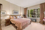 Experience serene mountain living in this charming bedroom, featuring a comfortable king-size bed adorned with a striped comforter and plush pillows.