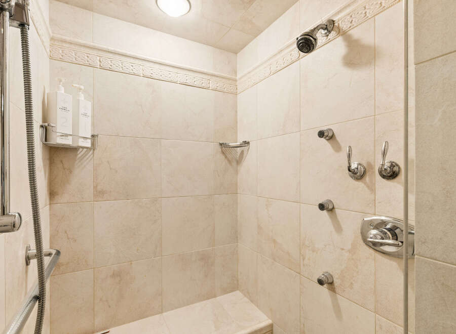 Experience ultimate relaxation in this luxurious shower featuring multiple shower heads for a spa-like experience.