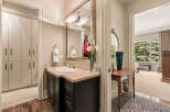 This luxurious bathroom features a spacious vanity with a marble countertop and a modern dark wood cabinet.