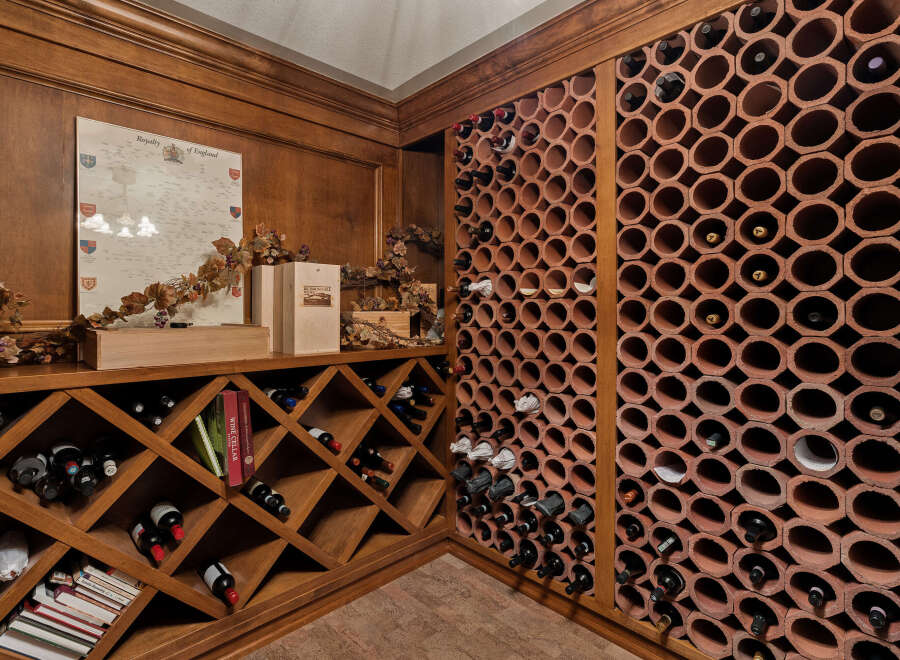 Discover this exquisite wine cellar, featuring a custom-built wooden wine rack system with diamond-shaped compartments perfect for storing your collection.